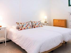 波里斯德阿沃納的住宿－Live el Poris chinchorro，卧室配有一张带两张桌子的大型白色床
