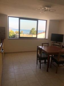 a living room with a table and a large window at La terrazza di Brancaccio’s house summer in Paola