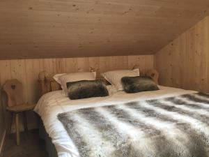 a bed with two pillows on it in a room at La Chabraque in Le Barboux