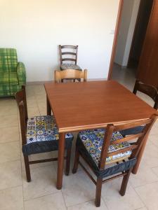 a wooden dining room table with two chairs and a bench at La terrazza di Brancaccio’s house summer in Paola
