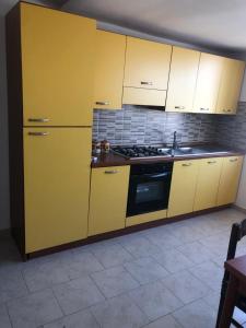 a kitchen with yellow cabinets and a stove at La terrazza di Brancaccio’s house summer in Paola