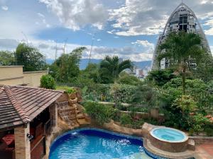 a swimming pool in a garden with a building at Serenity Suites Casa Boutique in Bucaramanga