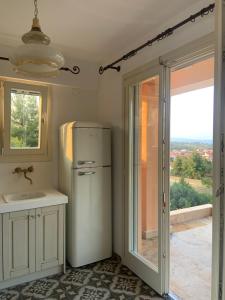 a kitchen with a refrigerator and a sink and a window at ST NIKOLA PANORAMIC SUITES HALKIDIKI in Agios Nikolaos