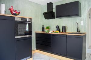 a kitchen with black cabinets and a sink at Wellness mitten in der Wasserfallstadt Triberg in Triberg