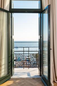 an open door to a balcony with a view of the ocean at EPICURE SUITES in Kavala