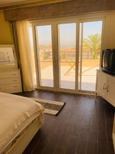 a bedroom with a bed and a sliding glass door at Lovely Villa 5- bedroom with Overflow Pool with Nice Garden at Green Oasis Resort in Alexandria