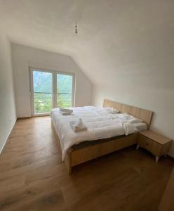 a bedroom with a bed and a large window at Villat Twin’s in Peje