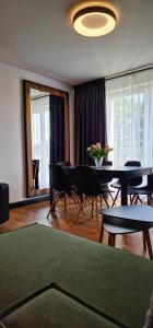 a living room with a table and chairs and a room with a table at Apartamenty Rzucewska 87 in Żelistrzewo