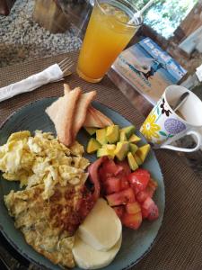 a plate of breakfast food with a glass of orange juice at Residencia El Balatà in Las Terrenas
