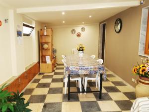 uma sala de jantar com uma mesa e cadeiras num piso em xadrez em PALOROSSO HOUSE em Donnalucata