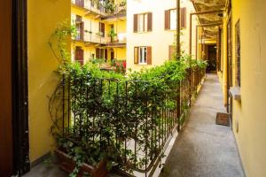 un callejón con una valla y plantas al lado de un edificio en Palm Apartment, en Milán
