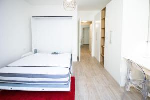 1 dormitorio con cama blanca y alfombra roja en Palm Apartment, en Milán