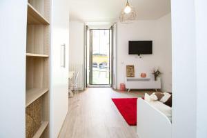 sala de estar con sofá blanco y alfombra roja en Palm Apartment, en Milán