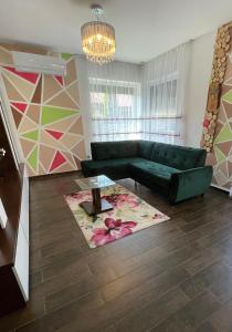 a living room with a green couch and a rug at Exkluzív Apartman Debrecen in Debrecen