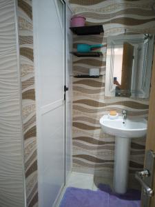 a bathroom with a sink and a mirror at LA PERLE DE L'OCEAN 1 in Akhfennirr