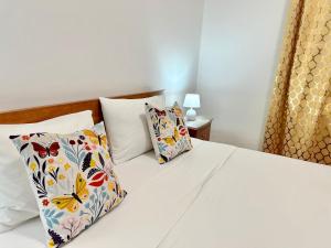 a white bed with two pillows on it at Sublime Yellow Bedroom in Lisbon