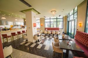 a restaurant with tables and chairs and a bar at Delphi Art Hotel by Prima Hotels in Athens