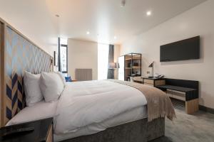 ein Schlafzimmer mit einem großen Bett und einem TV in der Unterkunft Sandman Signature Glasgow Hotel in Glasgow