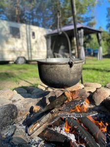 una olla sentada encima de un fuego en Viršu Glempings, en Engure