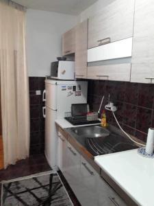cocina con fregadero y nevera blanca en Apartman u Kuci u Konjicu en Konjic