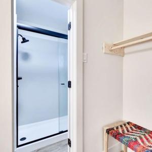 a glass door leading to a closet with a bench at Hotel McCoy - Art, Libations, Pool Society in College Station