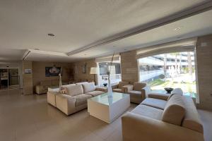 a living room with white furniture and a large window at Palmera Beach in Pilar de la Horadada