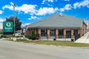 a building on the side of a street with a sign at Quality Inn in Grand Blanc