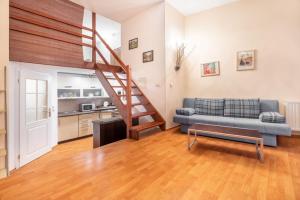 - un salon avec un canapé et un escalier dans l'établissement Apartment Above the Spring, à Karlovy Vary