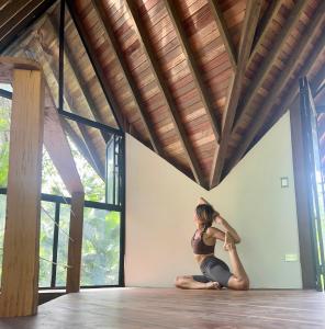 a woman doing a yoga pose in a room at Almara House in El Valle
