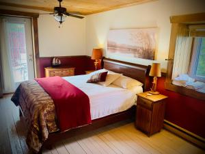 a bedroom with a large bed with a wooden headboard at Chalet & Gîte Capitainerie du Passant in Grandes-Piles
