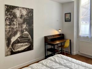 a bedroom with a desk and a painting on the wall at Magnifique maison classée 3 étoiles, 7 chambres, 5 salles de bain, parking privé, Tarbes ville in Tarbes
