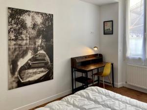 1 dormitorio con escritorio y una pintura en la pared en Magnifique maison classée 3 étoiles, 7 chambres, 5 salles de bain, parking privé, Tarbes ville, en Tarbes