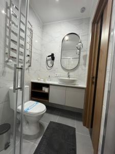 ein Badezimmer mit einem WC, einem Waschbecken und einem Spiegel in der Unterkunft Гірський Кришталь in Skole