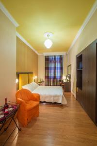 a bedroom with a bed and a couch and a chair at Delphi Art Hotel by Prima Hotels in Athens