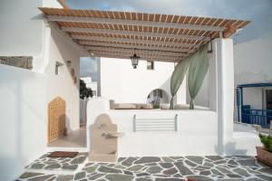 a white house with a wooden roof at Mythical Luxury Apartment in Naxos Chora