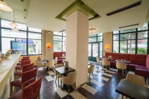 a restaurant with tables and chairs and windows at Delphi Art Hotel by Prima Hotels in Athens