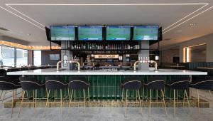 a bar with chairs and a counter with televisions at Sandman Signature Glasgow Hotel in Glasgow
