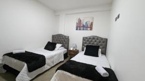 2 camas en una habitación con paredes blancas en Moderno Apto familiar piso 3 en Santa Rosa de Cabal
