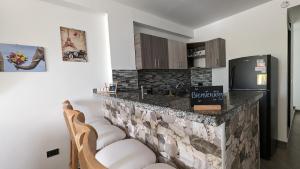 cocina con encimera con 2 sillas y nevera en Moderno Apto familiar piso 3, en Santa Rosa de Cabal