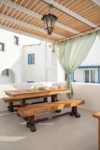 einen Holztisch und Bänke in einem Zimmer in der Unterkunft Mythical Luxury Apartment in Naxos Chora