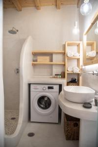 a bathroom with a washing machine and a sink at Mythical Luxury Apartment in Naxos Chora