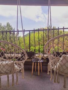 - une terrasse couverte avec 2 chaises et une table dans l'établissement Vikendica pod kulom, à Vršac