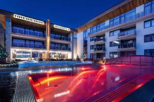 a hotel with a pool in front of a building at Studio A205 Hrebienok resort Starý Smokovec with garage in Vysoke Tatry - Stary Smokovec