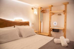a bedroom with a bed with white pillows and a ladder at Mythical Luxury Apartment in Naxos Chora