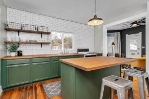 XeniaEnchanting Bungalow - 2BR Historic Hidden Gem的厨房配有绿色橱柜和木制台面