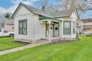 a white house with a porch and a grass yard at Enchanting Bungalow - 2BR Historic Hidden Gem in Xenia