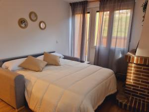 a bedroom with a large white bed and a window at Maile Apartamentos in Potes