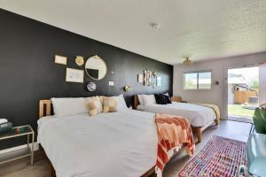 1 dormitorio con 2 camas y pared negra en Hotel McCoy - Art, Libations, Pool Society en College Station