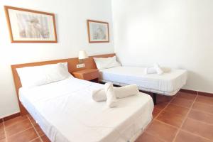 - 2 lits dans une chambre avec des draps blancs dans l'établissement Acogedor Ático en El Mirador, à Alcaidesa