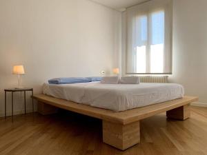 a bed sitting on a wooden bench in a bedroom at Your Loft - Treviso in Treviso